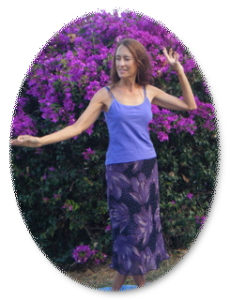 Deva doing Tantra Goddess Kundalini dance near purple flowers on Maui