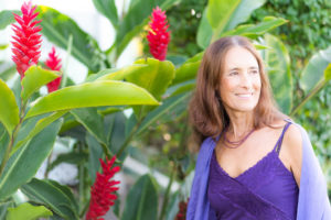 Intimacy Coach Deva Dasi with red ginger plants on Maui