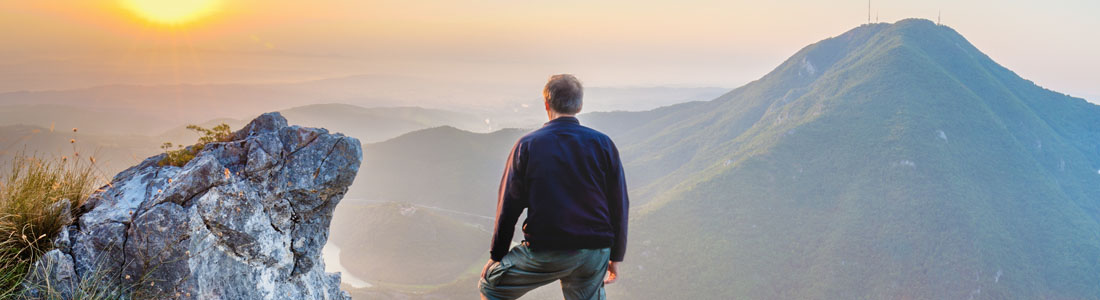 Maui Empowered Man looks out over mountains at sunset.